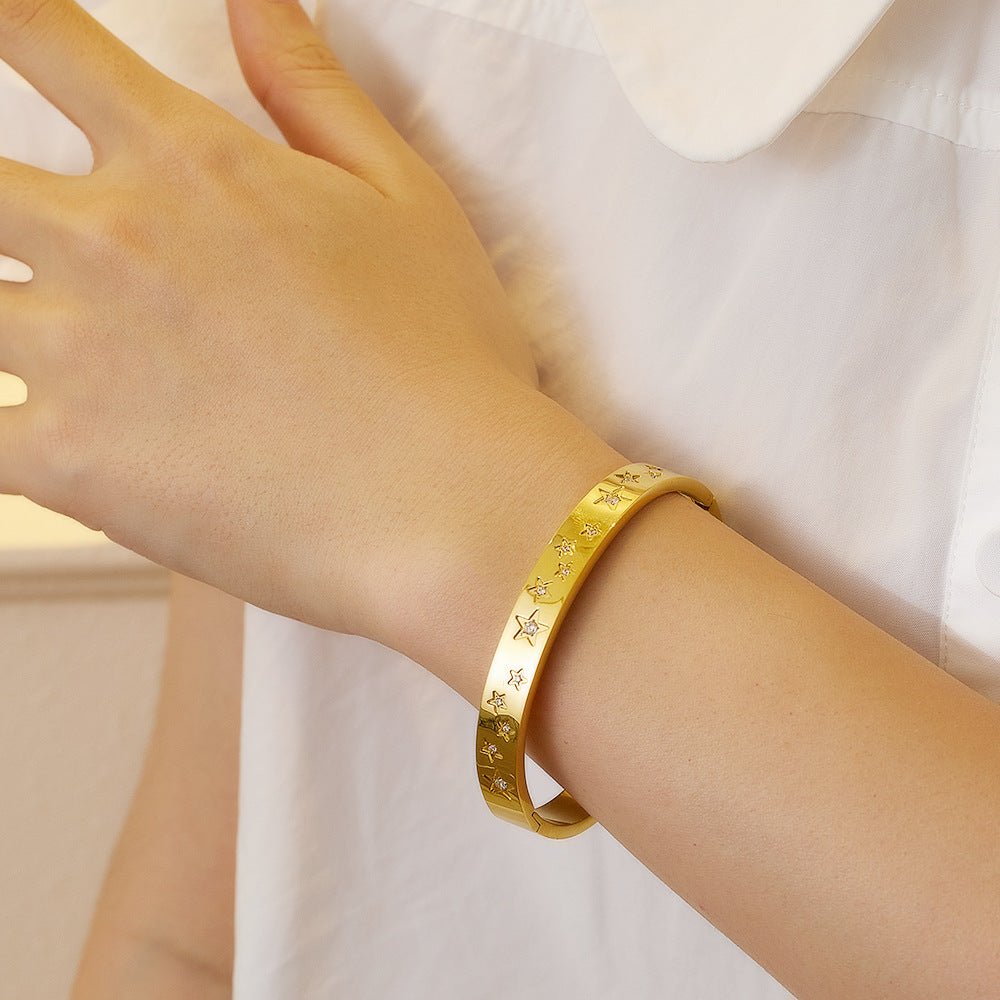 Γυναικείο βραχιόλι χειροπέδα ατσάλινη με χαραγμένα αστέρια και ζιργκόν επιχρυσωμένη (B1482) - bracelet - charmy.gr